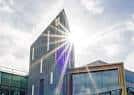 Edificio moderno con fachada de vidrio y sol brillante