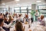 Evento corporativo o cena en el salón de INOX con invitados sentados a las mesas