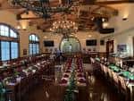 Sala de eventos interior con mesas dispuestas para una celebración y decoración festiva