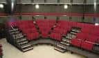 Interior del auditorio con butacas rojas y escenario