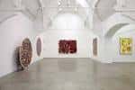Interior de una sala de exposiciones con arte contemporáneo y techos altos