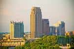 Vista panorámica de Atlantic Station con rascacielos y edificios modernos bajo un cielo dorado
