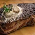 Plato de carne a la parrilla con salsa y hierbas frescas