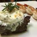 Carne cocinada con guarnición de camarones y salsa cremosa