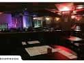 Interior del Helium Comedy Club con mesas y escenario iluminado