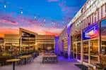 Vista exterior del Punch Line Comedy Club al atardecer con terraza