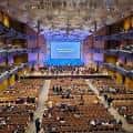 Vista general del salón principal durante un concierto con escenario iluminado