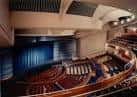 Interior del teatro mostrando la disposición de las gradas y el telón azul