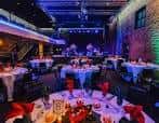 Interior del Fine Line configurado para una cena formal con mesas redondas y decoración elegante