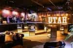 Área de bar y lounge en Soundwell con iluminación cálida y decoración moderna