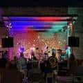 Público disfrutando de un evento nocturno bajo luces multicolores