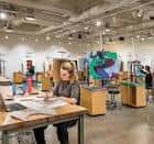 Interior de un espacio creativo con mesas y obras de arte