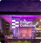 Fachada iluminada de Embarc Collective por la noche