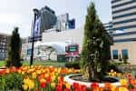 Jardín floral en el Columbus Commons con árboles ornamentales y letreros de bienvenida