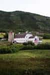 Vista exterior del White Barn en Park City Utah rodeado de campo verde y montañas