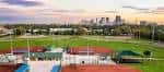 Vista panorámica del Lou Berliner Sports Park con campos deportivos y skyline de Columbus al fondo