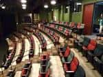 Interior del teatro con filas de asientos rojos
