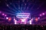 Interior del salón principal con escenario iluminado y público durante un evento