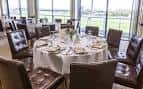 Sala de eventos privada con mesas redondas y vistas al hipódromo
