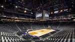 Interior del arena durante un evento con cancha de baloncesto iluminada