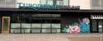 Fachada exterior del Turquoise Wine Bar con letrero iluminado y murales florales