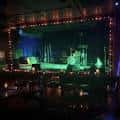 Escenario principal con iluminación verde y equipo de sonido