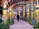 Pasillo iluminado con columnas decorativas y vegetación en el interior del centro