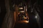Vista interior del túnel con iluminación tenue y detalles arquitectónicos históricos