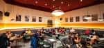 Cafetería interior con mesas y decoración moderna