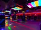 Pista de baile del club con luces multicolores y ambiente festivo