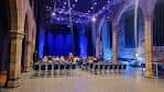 Interior del auditorio con iluminación azul y butacas dispuestas para evento