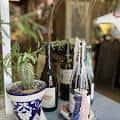 Mesa con botellas de vino y maceta decorativa en ambiente interior