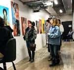 Interior del centro mostrando una exposición de arte con visitantes observando las obras
