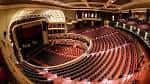 Vista panorámica del interior del auditorio con butacas rojas y techo ornamentado