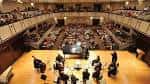Concierto en el auditorio con orquesta en escena y público sentado
