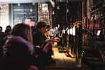 Bar interior con ambiente acogedor y clientes disfrutando