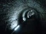 Interior del Victoria Tunnel con paredes de ladrillo y luces tenues