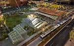 Vista aérea del Civic Space Park con sus característicos toldos de sombra y el tren ligero pasando