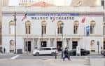 Fachada principal del Walnut Street Theatre en Filadelfia con banderas y entrada iluminada