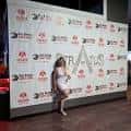 Mujer posando frente a pared de marca en evento del Stratus Event Center