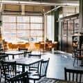 Interior del espacio de Brühaven Craft Co. con mesas y sillas dispuestas para eventos