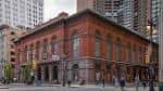 Vista exterior del Academy of Music en Filadelfia, mostrando su fachada histórica de ladrillo rojo y arquitectura clásica