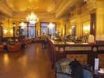 Interior elegante del salón principal con iluminación cálida y decoración victoriana