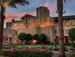 Vista exterior del Arizona Biltmore al atardecer con palmeras y jardines iluminados