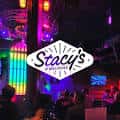 Vista nocturna del exterior de Stacy's @ Melrose con iluminación colorida y letrero distintivo