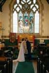 Ceremonia de boda dentro de la capilla con vitrales y decoración tradicional
