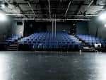 Interior del auditorio del Unity Theatre con butacas azules y escenario vacío