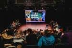Evento en el Unity Theatre con público sentado frente a pantalla de proyección
