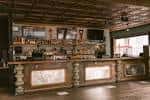 Interior del bar principal con acabados rústicos y barra decorativa lista para eventos