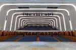 Vista interior del auditorio con iluminación moderna y butacas de madera